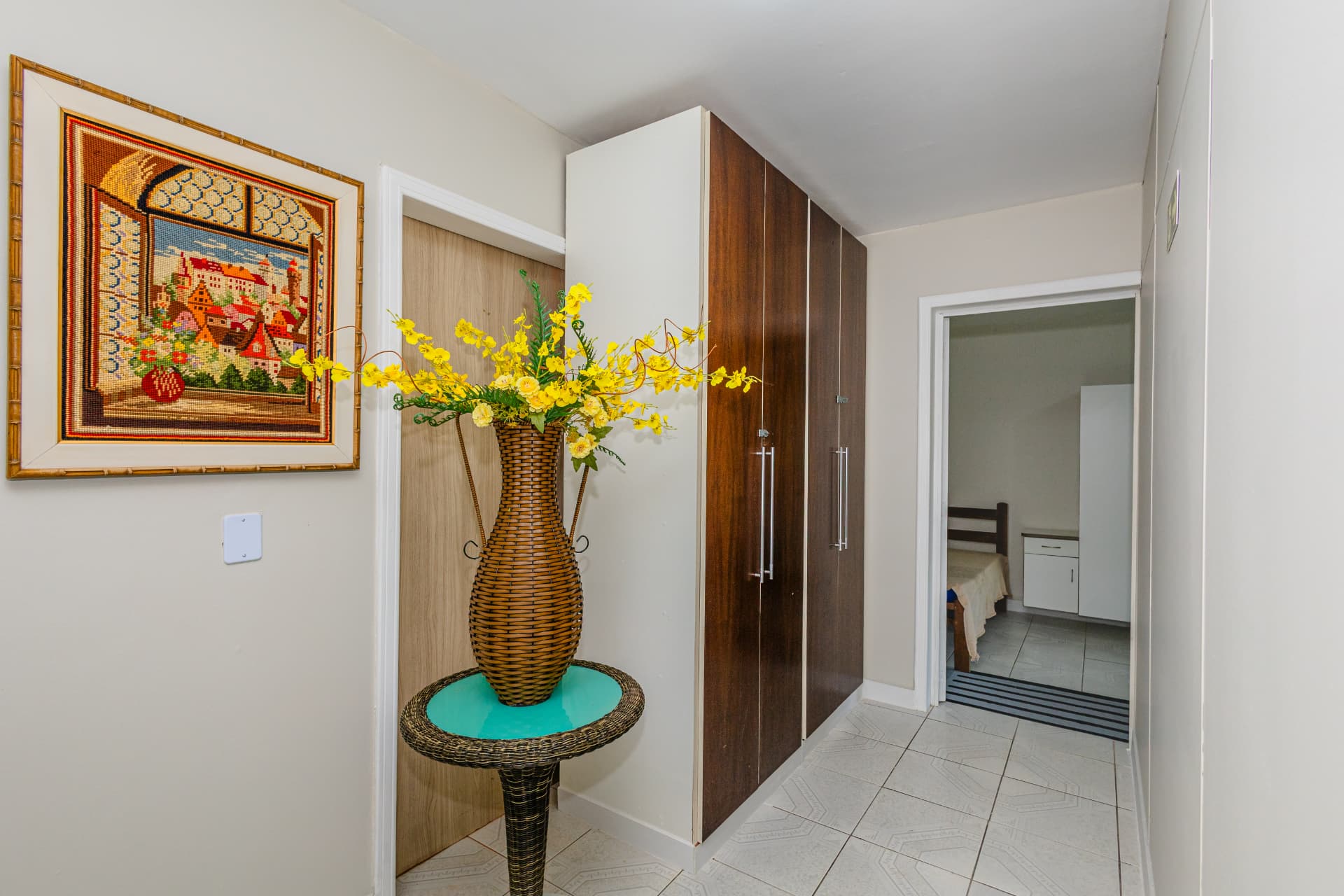 Corredor com guarda-roupa de madeira e mesa lateral decorada