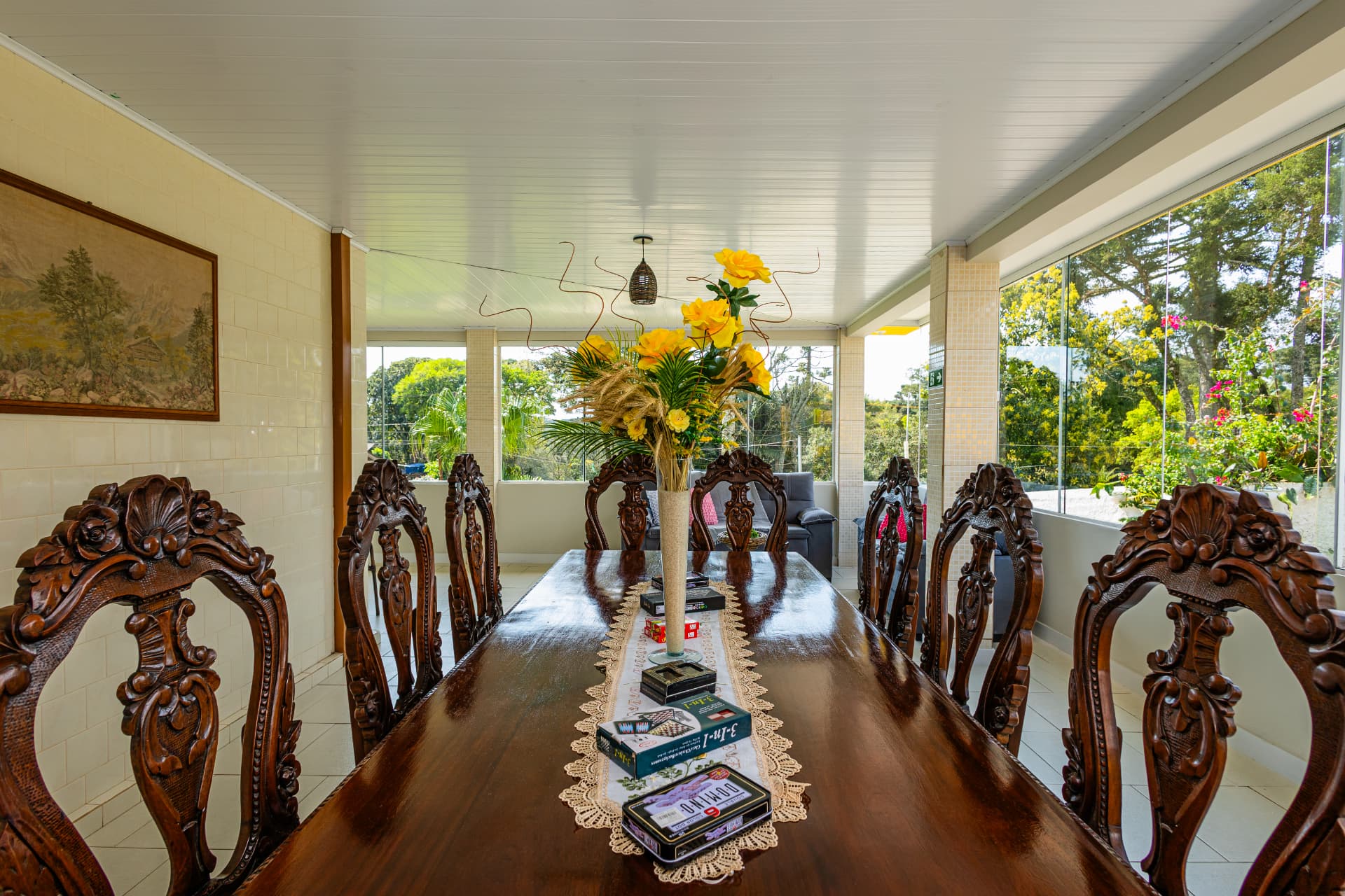 Sala de jantar com mesa de madeira e jogos de tabuleiro sobre o tampo